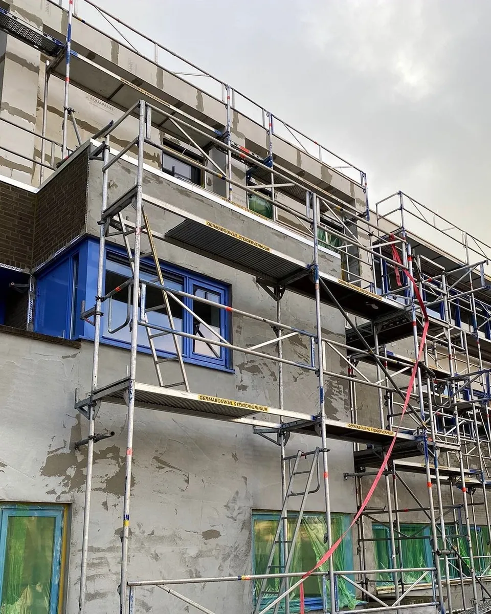 Portiekflat met blauwe kozijnen in de steigers