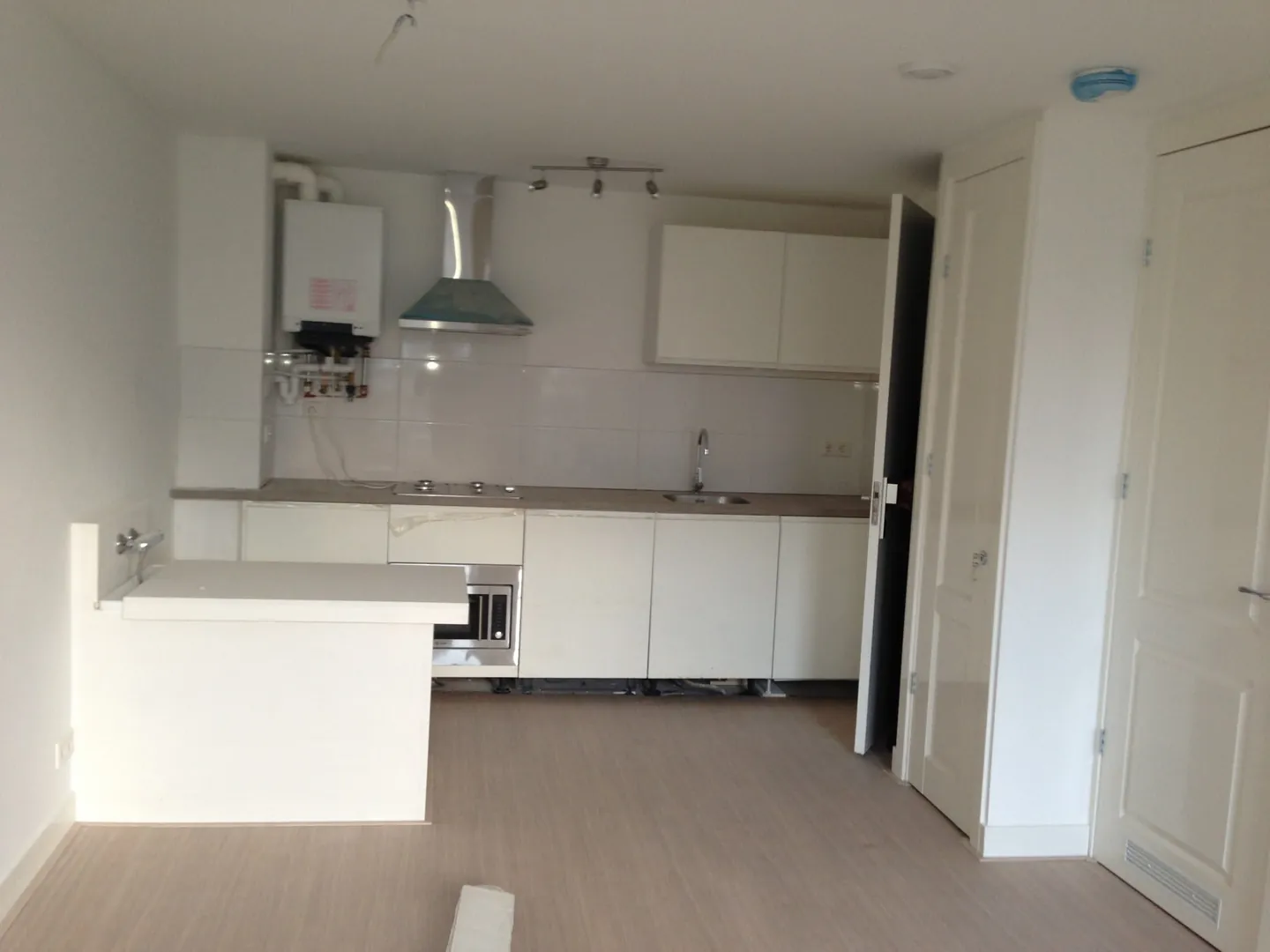 Opgeleverd appartement met witte keuken en lichte vloer
